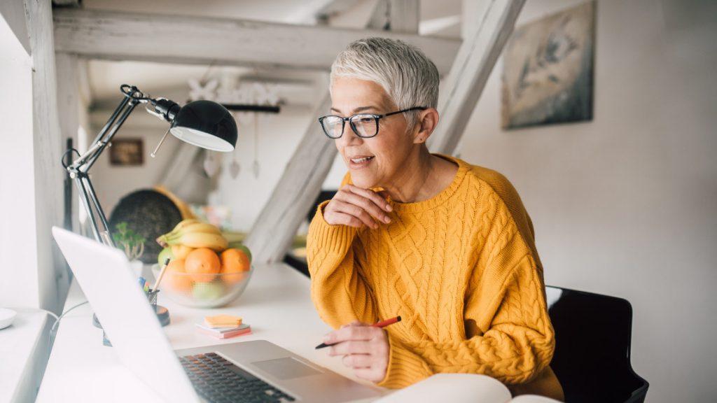 Older person working in front of a laptop computer